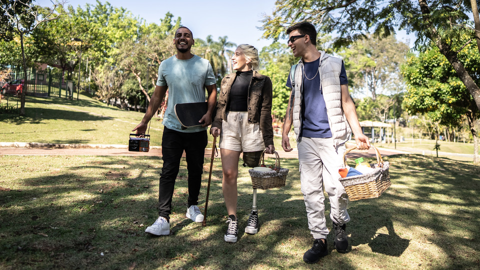 Students walk through a green park area on a sunny day.