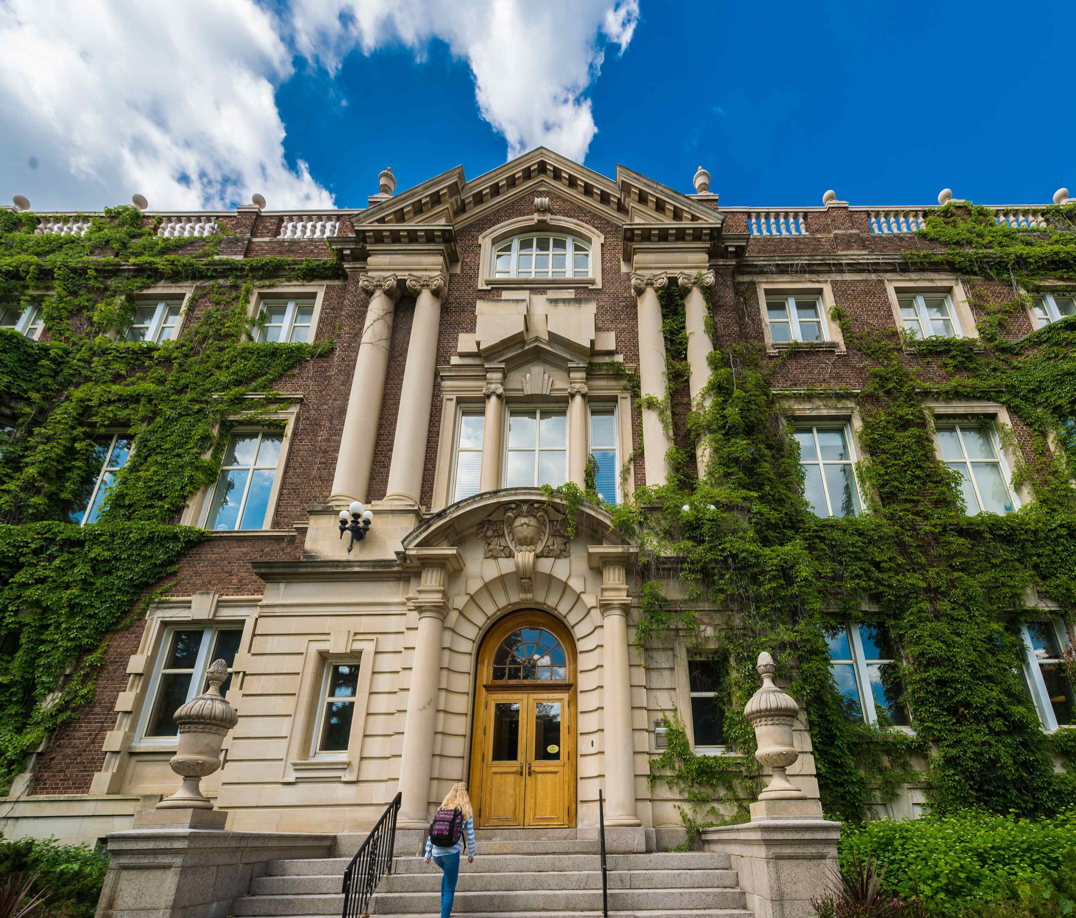 Exterior view of the Arts & Convocation Hall Building, a tall brick building with a vibrant blue sky in the background.