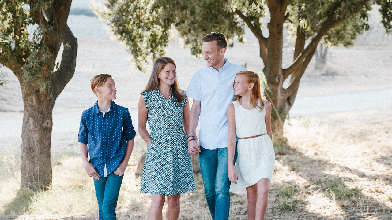 Family walking outside by trees